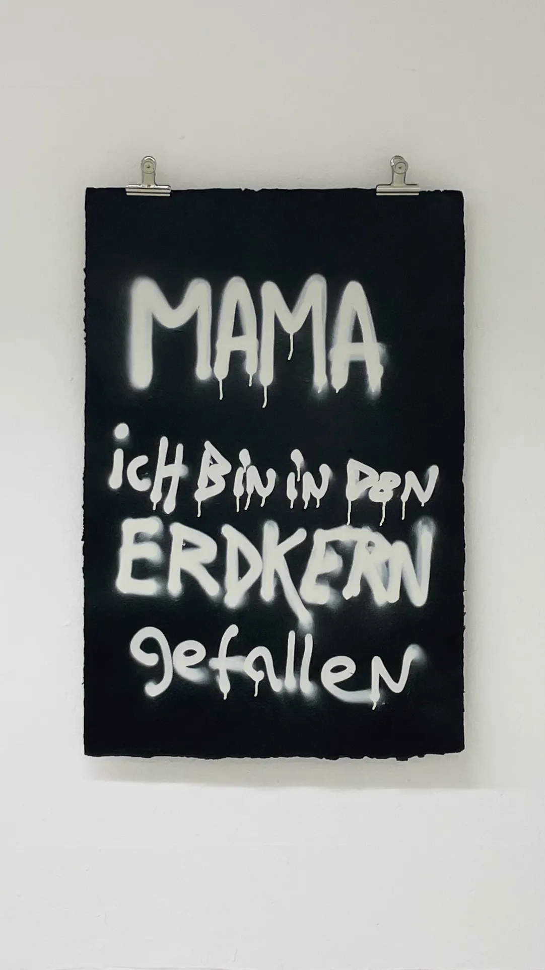 Front view of the artwork held by metal clips hanging on nails